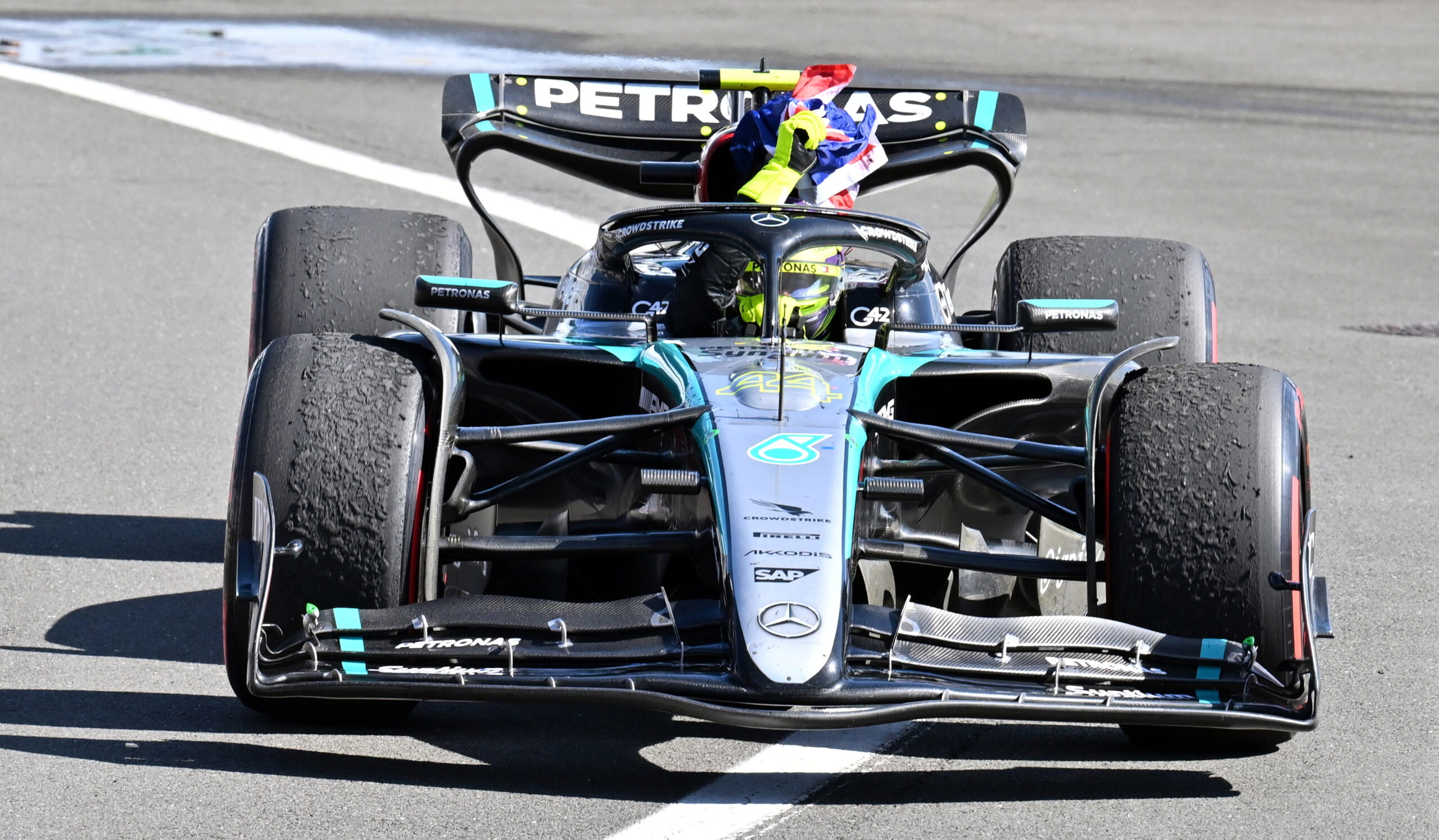 Hamilton ondea la bandera británica durante su vuelta de victoria